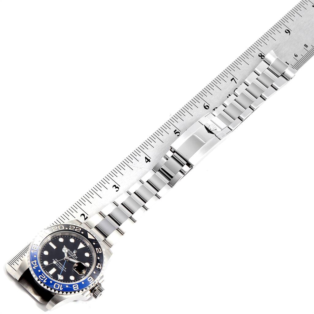 The image shows a top view of the Rolex GMT-Master 116710 Men's Stainless Steel Black Dial 116710 Men's Stainless Steel Black Dial watch with its stainless steel bracelet laid alongside a ruler.