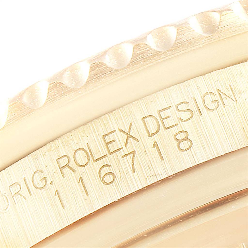 This close-up image shows the engraved 'ROLEX DESIGN' and model number on the case of a Rolex GMT-Master 116718 Men's Yellow Gold Green Dial 116718 Men's Yellow Gold Green Dial watch.