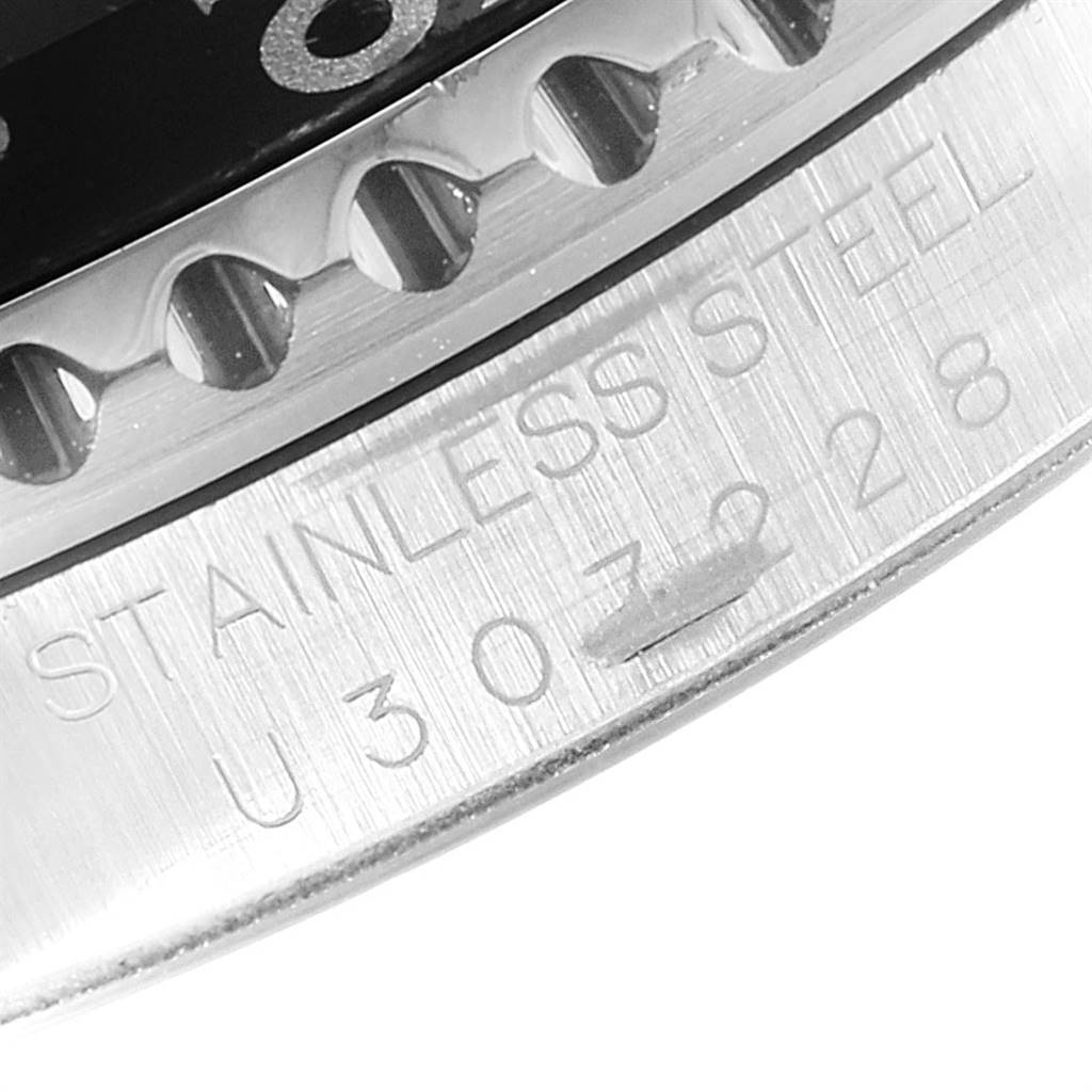 This close-up angle of the Rolex GMT-Master 16700 Men's Stainless Steel Black Dial 16700 Men's Stainless Steel Black Dial watch shows the bezel edge and part of the stainless steel casing with engraved text.