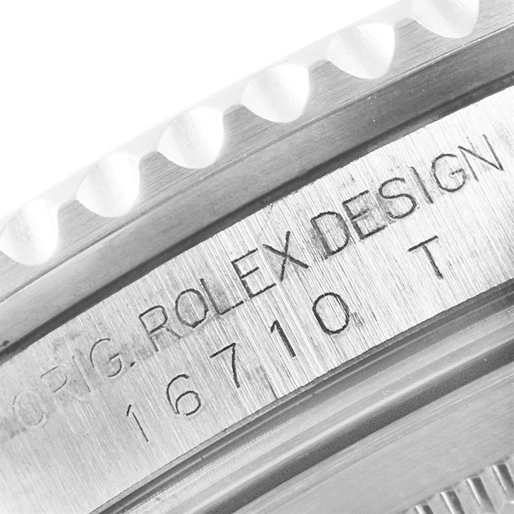 This image shows a close-up of the engraved side of the bezel and case side of a Rolex GMT-Master 16710 Men's Stainless Steel Black Dial 16710 Men's Stainless Steel Black Dial watch.