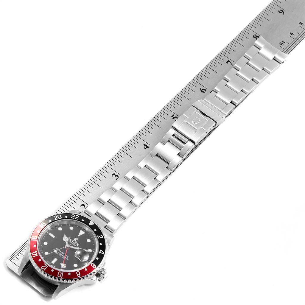 The image shows a Rolex GMT-Master 16710 Men's Stainless Steel Black Dial 16710 Men's Stainless Steel Black Dial watch laid over a ruler, displaying the watch face and metal bracelet in a top-down angle.