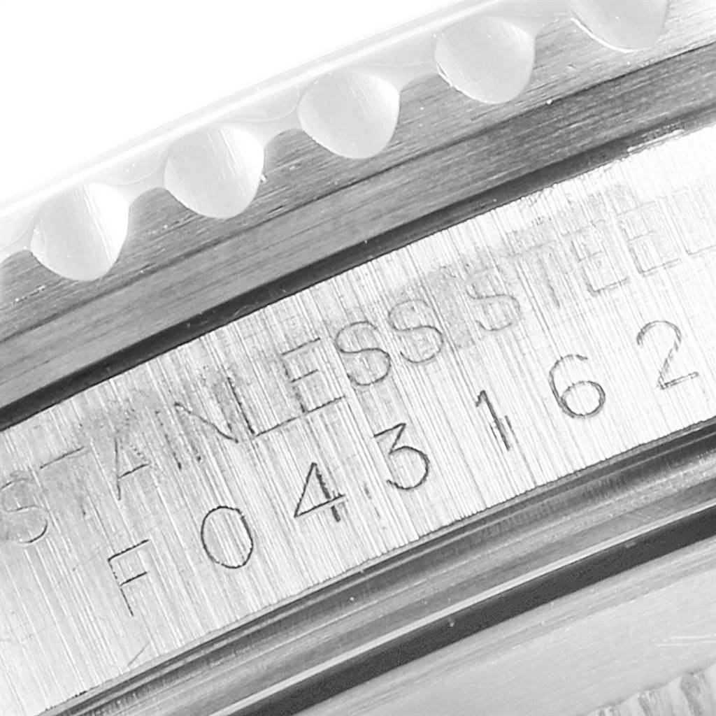 The image shows a close-up of the serial number and part of the bezel of a Rolex GMT-Master 16710 Men's Stainless Steel Black Dial 16710 Men's Stainless Steel Black Dial watch.