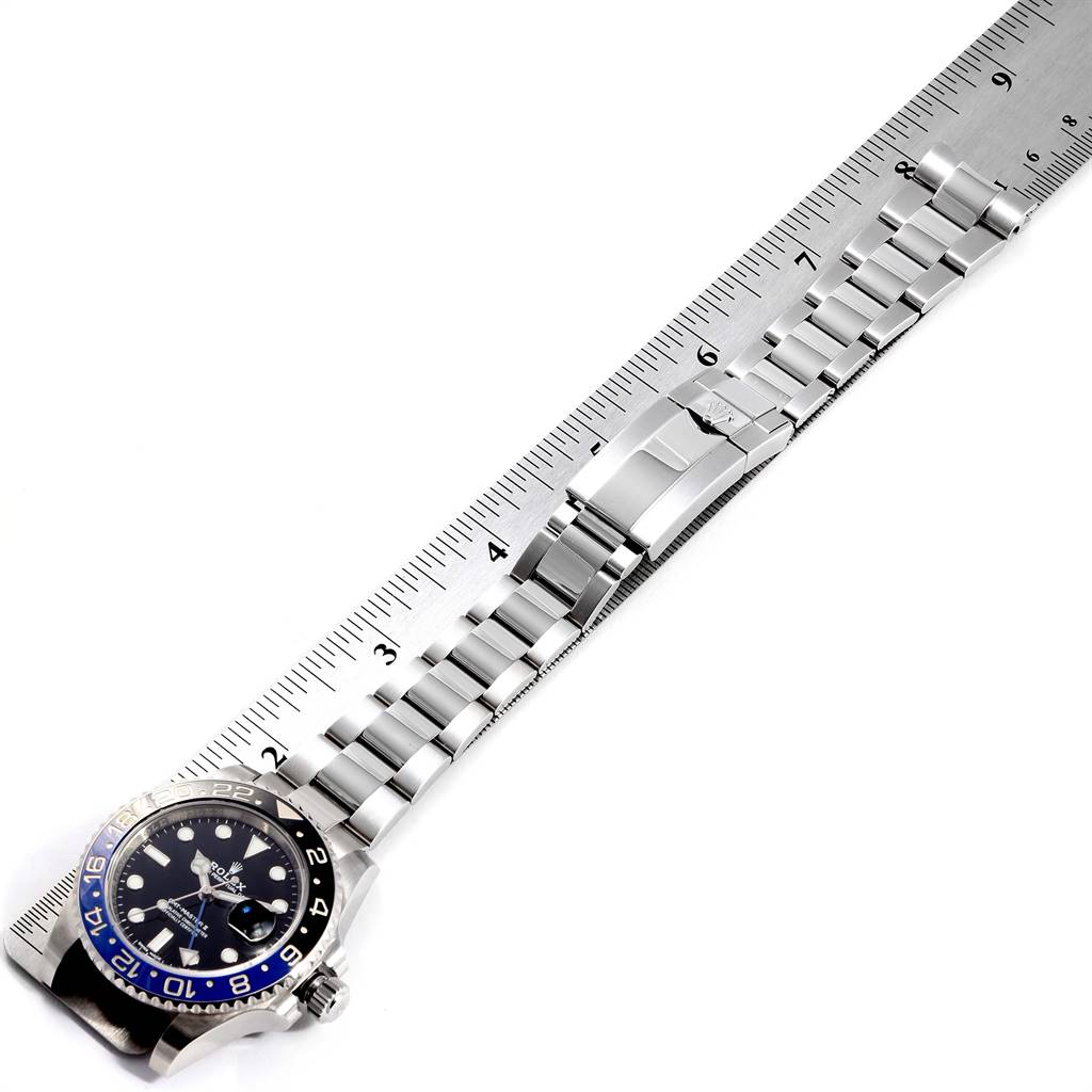 This image shows the Rolex GMT-Master 116710 Men's Stainless Steel Black Dial 116710 Men's Stainless Steel Black Dial watch horizontally alongside a ruler, showcasing its face and bracelet.