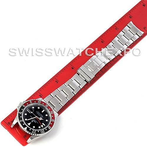 This image shows a top-down view of a Rolex GMT-Master 16710 Men's Stainless Steel Black Dial 16710 Men's Stainless Steel Black Dial watch alongside a red ruler for scale.