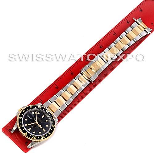 The Rolex GMT-Master 16713 Men's Stainless Steel Black Dial 16713 Men's Stainless Steel Black Dial watch is shown from a top-down angle, displaying its gold and silver bracelet and black dial.