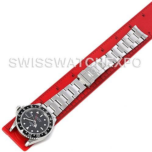 The image shows an overhead view of a Rolex GMT-Master 16710 Men's Stainless Steel Black Dial 16710 Men's Stainless Steel Black Dial watch laid flat next to a measurement scale.