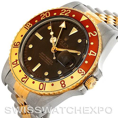 The image shows a close-up of a Rolex GMT-Master 16753 Men
s Stainless Steel Brown Dial 16753 Men
s Stainless Steel Brown Dial watch, highlighting the bezel, dial, and crown from an angled perspective.