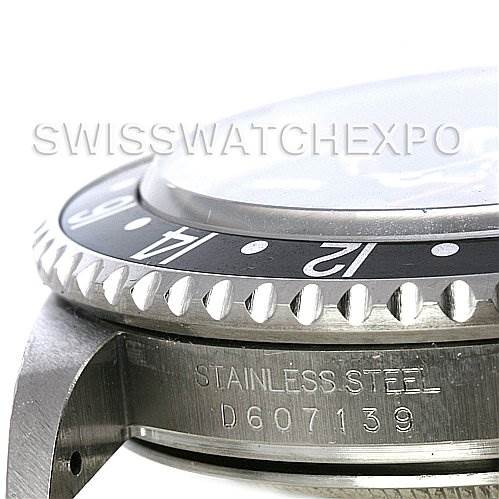 This close-up angle of the Rolex GMT-Master 16710 Men's Stainless Steel Black Dial 16710 Men's Stainless Steel Black Dial shows its bezel, crystal, and part of its stainless steel case with a serial number.
