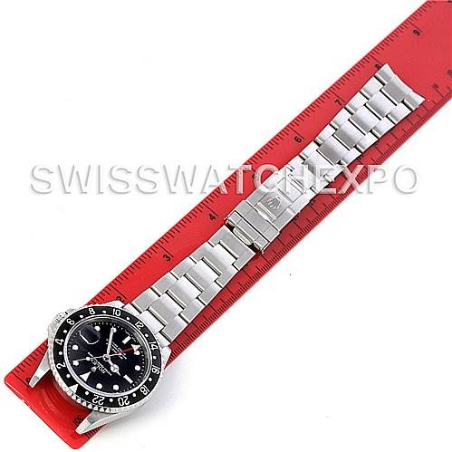 The Rolex GMT-Master 16710 Men's Stainless Steel Black Dial 16710 Men's Stainless Steel Black Dial watch is displayed flat on a red ruler, showing the face, bezel, and bracelet.