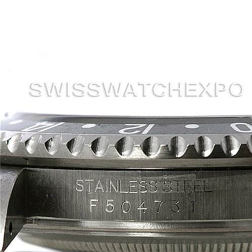The image shows a close-up of the bezel and part of the case of a Rolex GMT-Master 16710 T Men's Stainless Steel Black Dial 16710 T Men's Stainless Steel Black Dial, highlighting its stainless steel material and serial number.