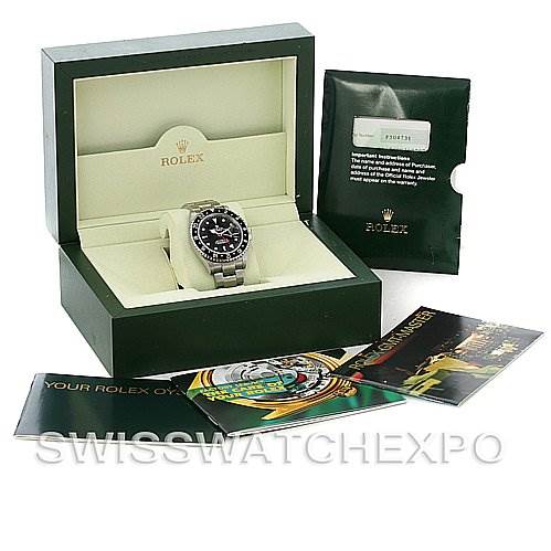 The image shows a Rolex GMT-Master 16710 T Men's Stainless Steel Black Dial 16710 T Men's Stainless Steel Black Dial watch displayed in its open box, along with accompanying booklets, warranty card, and a green sleeve.
