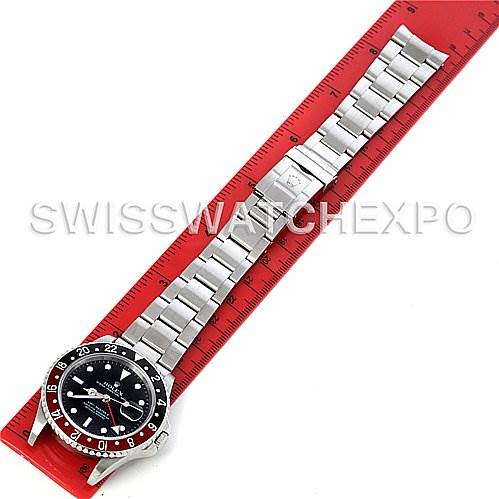 This image shows a top-down view of a Rolex GMT-Master 16710 Men's Stainless Steel Black Dial 16710 Men's Stainless Steel Black Dial watch laid out on a ruler, displaying the full bracelet and bezel.
