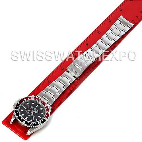 The Rolex GMT-Master 16710 Men's Stainless Steel Black Dial 16710 Men's Stainless Steel Black Dial watch is shown from a top-down angle, displaying the face, bracelet, and clasp against a red ruler.