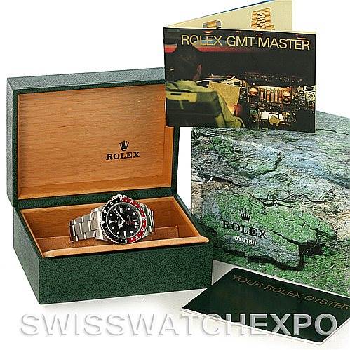 The image shows a Rolex GMT-Master 16710 Men's Stainless Steel Black Dial 16710 Men's Stainless Steel Black Dial watch in a green box along with its manual and packaging.