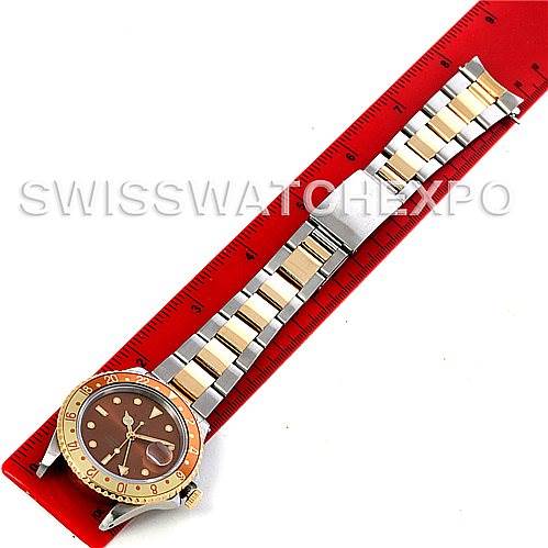 This is an overhead view of a Rolex GMT-Master 16713 Men
s Stainless Steel Brown Dial 16713 Men
s Stainless Steel Brown Dial watch, showcasing the face, bezel, and full bracelet against a red ruler.