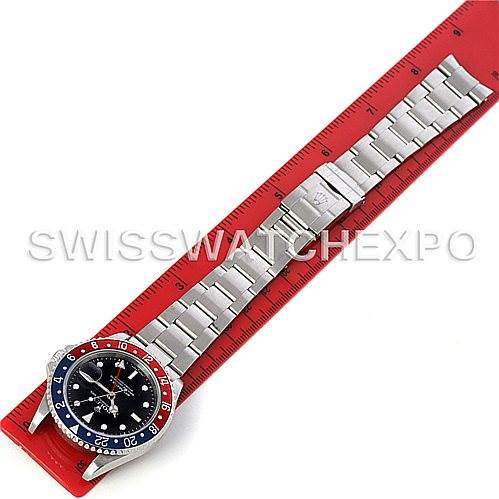 This image shows a Rolex GMT-Master 16710 Men's Stainless Steel Black Dial 16710 Men's Stainless Steel Black Dial watch laid flat next to a red ruler, displaying the entire watch and its bracelet.