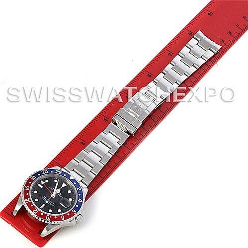 The image shows a Rolex GMT-Master 16710 Men's Stainless Steel Black Dial 16710 Men's Stainless Steel Black Dial watch, placed horizontally on a red ruler, displaying the dial, bezel, and stainless steel bracelet.