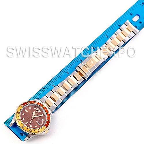 The image shows a top-down view of a Rolex GMT-Master 16713 Men's Stainless Steel Brown Dial 16713 Men's Stainless Steel Brown Dial watch placed alongside a blue ruler.