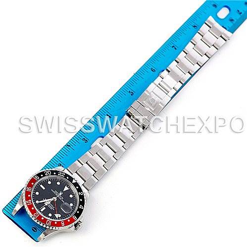 The image shows a Rolex GMT-Master 16710 Men
s Stainless Steel Black Dial 16710 Men
s Stainless Steel Black Dial watch laid flat alongside a blue ruler, highlighting the bezel, dial, and metal bracelet.