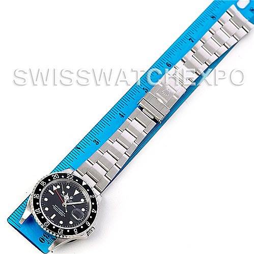 The image shows a top-down view of a Rolex GMT-Master 16710 Men's Stainless Steel Black Dial 16710 Men's Stainless Steel Black Dial watch placed next to a blue ruler, displaying the watch and metal bracelet.