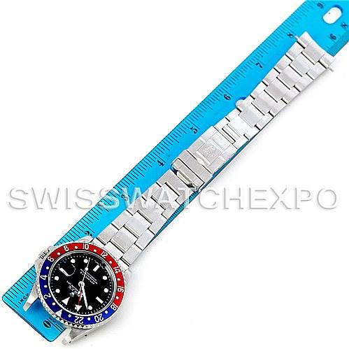The image shows a top-down view of a Rolex GMT-Master 16710 Men's Stainless Steel Black Dial 16710 Men's Stainless Steel Black Dial watch, including the bezel, dial, and bracelet, lying next to a blue ruler.
