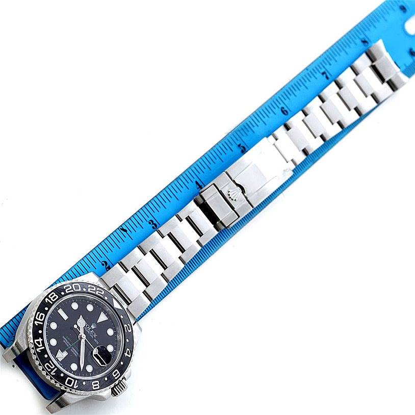 This image shows a Rolex GMT-Master 116710 Men's Stainless Steel Black Dial 116710 Men's Stainless Steel Black Dial watch laid flat against a ruler, capturing its face, bezel, and bracelet from a top-down angle.