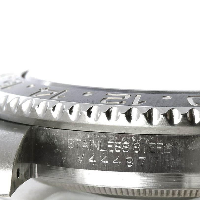 This image shows a close-up of the stainless steel bezel, case, and engraved serial number on a Rolex GMT-Master 116710 Men's Stainless Steel Black Dial 116710 Men's Stainless Steel Black Dial watch.