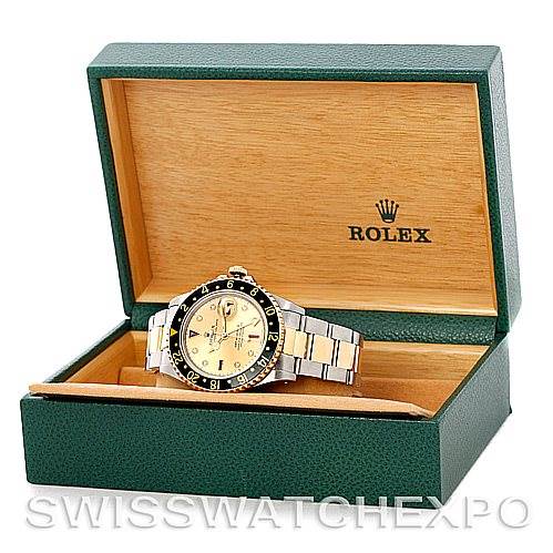 The Rolex GMT-Master 16713 Men's Stainless Steel Champagne Dial 16713 Men's Stainless Steel Champagne Dial watch is displayed at an angle inside a green box with a wood interior, showing the face and bracelet.