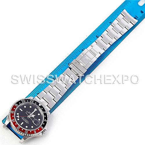 The image shows a top-down view of a Rolex GMT-Master 16710 Men's Stainless Steel Black Dial 16710 Men's Stainless Steel Black Dial watch, featuring the face and whole band laid next to a blue ruler.