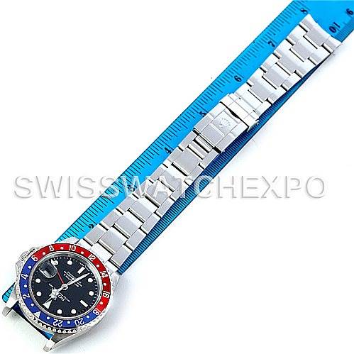 The image shows the top view of the Rolex GMT-Master 16710 Men's Stainless Steel Black Dial 16710 Men's Stainless Steel Black Dial watch, featuring the full bracelet and "Pepsi" bezel, laid next to a ruler.