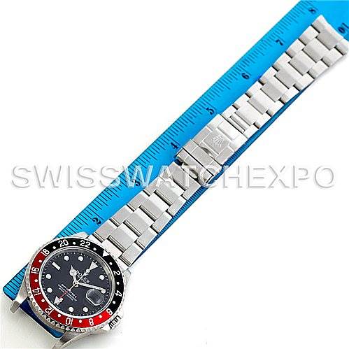 The image shows a top-down view of a Rolex GMT-Master 16710 Men's Stainless Steel Black Dial 16710 Men's Stainless Steel Black Dial watch against a blue ruler, displaying the face, bezel, and bracelet.