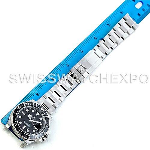 This image shows a full view from above of a Rolex GMT-Master 116710 Men's Stainless Steel Black Dial 116710 Men's Stainless Steel Black Dial watch with its bracelet fully extended alongside a blue ruler.