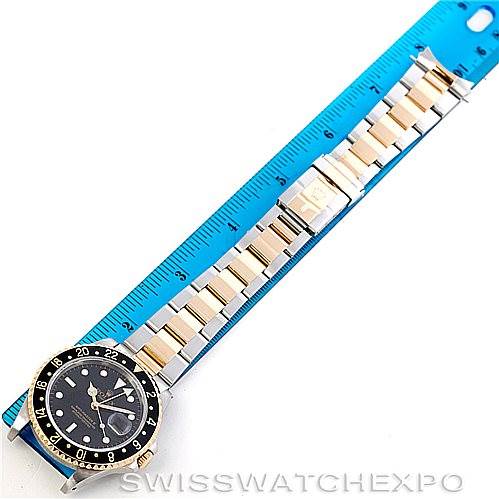 The Rolex GMT-Master 16713 Men's Stainless Steel Black Dial 16713 Men's Stainless Steel Black Dial watch is photographed from above, showing the face, bezel, bracelet, and part of a blue ruler for scale.