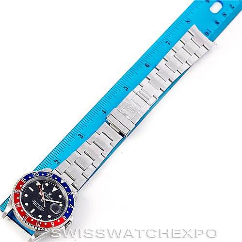 This image shows a Rolex GMT-Master 16710 Men's Stainless Steel Black Dial 16710 Men's Stainless Steel Black Dial watch laid flat alongside a ruler, highlighting its bracelet and clasp.
