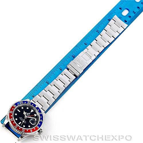 The image shows a top-down view of a Rolex GMT-Master 16710 Men's Stainless Steel Black Dial 16710 Men's Stainless Steel Black Dial with a "Pepsi" bezel, placed next to a blue measuring ruler.