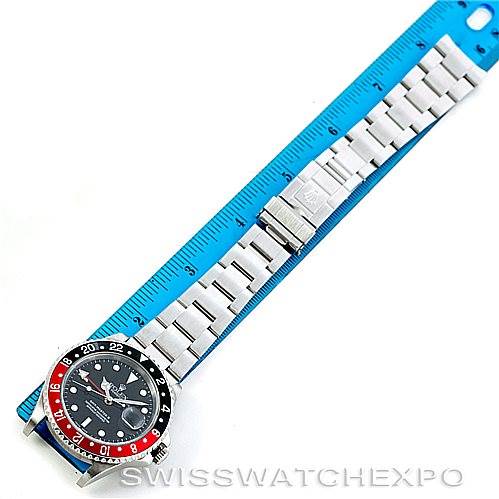 The image shows a top-down view of a Rolex GMT-Master 16710 Men's Stainless Steel Black Dial 16710 Men's Stainless Steel Black Dial watch with a Pepsi bezel, aligned next to a blue ruler for reference.