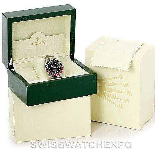 This image shows a Rolex GMT-Master 16710 Men's Stainless Steel Black Dial 16710 Men's Stainless Steel Black Dial watch inside its open green box, with outer packaging and a cleaning cloth beside it.