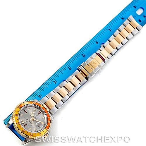 The image shows a full top view of a Rolex GMT-Master 16713 Men's Stainless Steel Grey Dial 16713 Men's Stainless Steel Grey Dial watch placed alongside a blue ruler for scale.