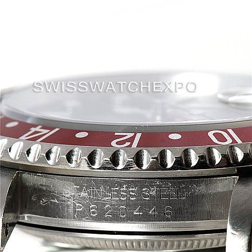 The image shows a close-up view of the GMT-Master Rolex watch’s bezel, case, and part of the serial number.