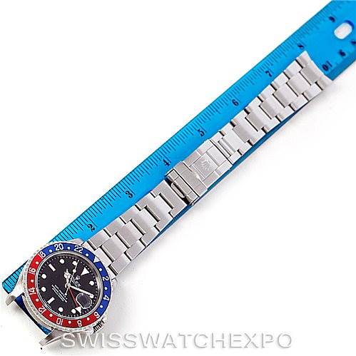 The image shows a top-down view of a Rolex GMT-Master 16710 Men's Stainless Steel Black Dial 16710 Men's Stainless Steel Black Dial watch, including the bezel, dial, and bracelet, placed next to a blue ruler.