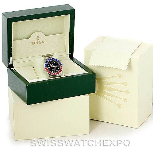 The image shows a Rolex GMT-Master 16710 Men's Stainless Steel Black Dial 16710 Men's Stainless Steel Black Dial watch in a green open box with a closed beige outer box and a beige cleaning cloth.