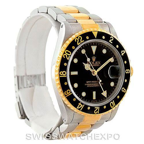 The image shows a Rolex GMT-Master 16713 Men
s Stainless Steel Black Dial 16713 Men
s Stainless Steel Black Dial watch at an angle displaying the two-tone bracelet, bezel, and face with a date magnifier.