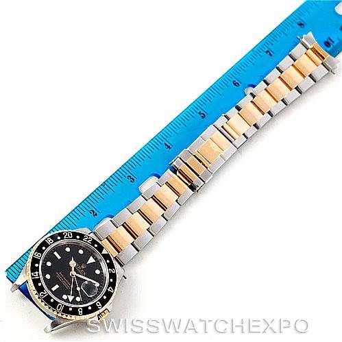 The image shows a top-down view of the Rolex GMT-Master 16713 Men
s Stainless Steel Black Dial 16713 Men
s Stainless Steel Black Dial watch, displaying its face and entire bracelet against a ruler.