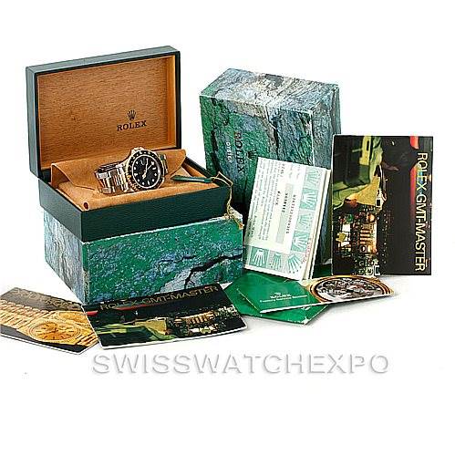 The image shows a Rolex GMT-Master 16713 Men's Stainless Steel Black Dial 16713 Men's Stainless Steel Black Dial watch angled slightly to the left with its box and various accessories, including booklets and certificates.