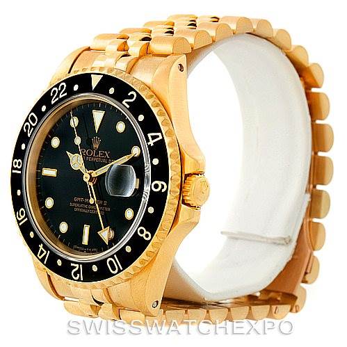 The image shows a gold Rolex GMT-Master 16718 Men's Yellow Gold Black Dial 16718 Men's Yellow Gold Black Dial wristwatch at an angle displaying its face, bezel, and part of the bracelet.