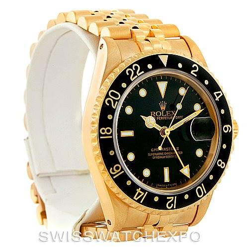 The image shows a Rolex GMT-Master 16718 Men's Yellow Gold Black Dial 16718 Men's Yellow Gold Black Dial II watch from an angle highlighting the dial, bezel, and bracelet.