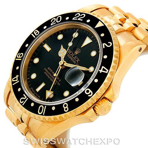 The image shows a close-up angle of a Rolex GMT-Master 16718 Men's Yellow Gold Black Dial 16718 Men's Yellow Gold Black Dial watch featuring the bezel, dial, crown, and part of the bracelet.