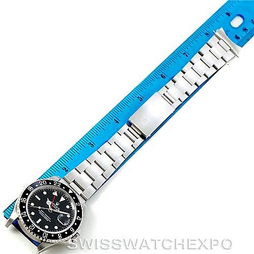 This Rolex GMT-Master 16700 Men's Stainless Steel Black Dial 16700 Men's Stainless Steel Black Dial watch is shown from a top-down angle, displaying the full band and face next to a blue ruler.