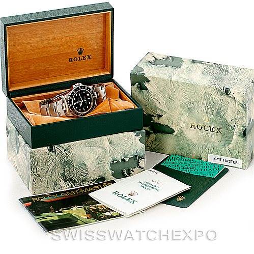 The image shows a Rolex GMT-Master 16700 Men's Stainless Steel Black Dial 16700 Men's Stainless Steel Black Dial watch with its box, outer carton, warranty card, and manuals.