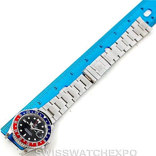 The image shows a bird's-eye view of a Rolex GMT-Master 16710 Men's Stainless Steel Black Dial 16710 Men's Stainless Steel Black Dial watch alongside a measuring ruler, focusing on the entire watch and its bracelet.